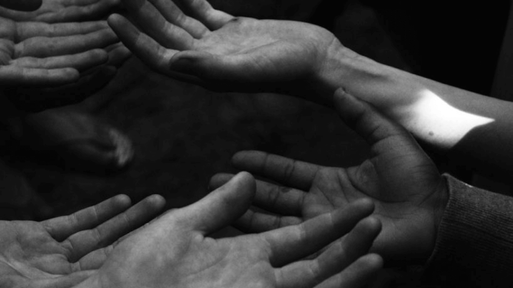 Várias mãos juntas em preto e branco